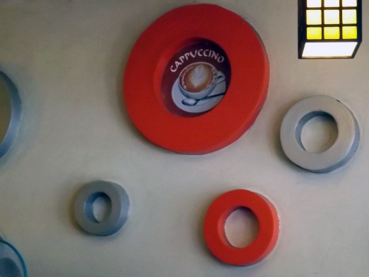 Concentric rings in silver and red decorate a wall in Cafe Deli.